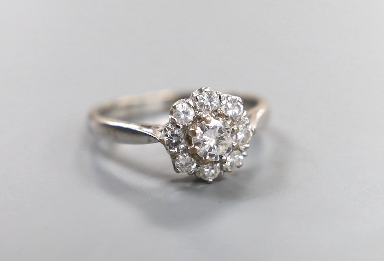 A modern 18ct white gold and nine stone diamond set flower head cluster ring